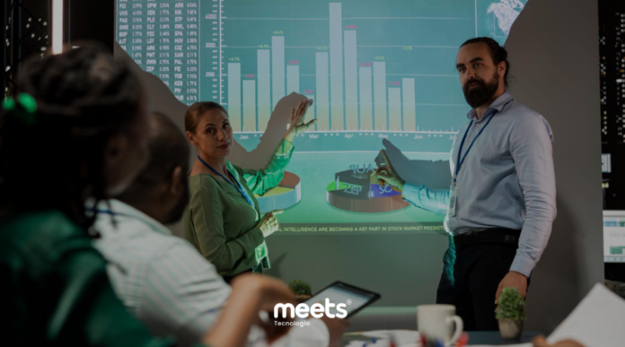 Equipe analisando gráfico de forecast de vendas projetado em tela, discutindo previsões comerciais e tomada de decisão baseada em dados.