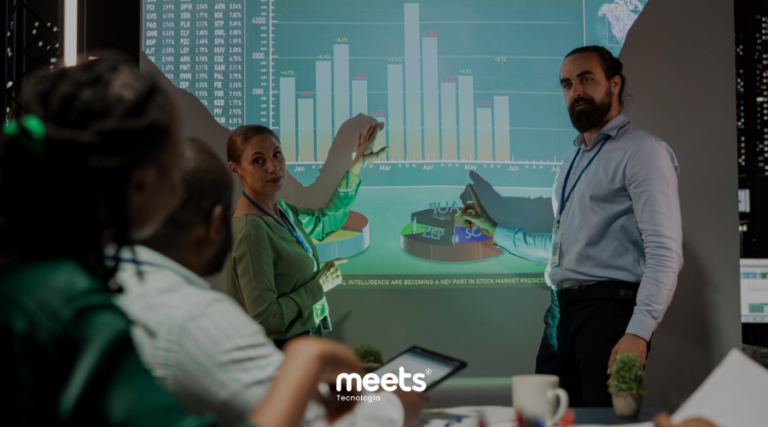 Equipe analisando gráfico de forecast de vendas projetado em tela, discutindo previsões comerciais e tomada de decisão baseada em dados.