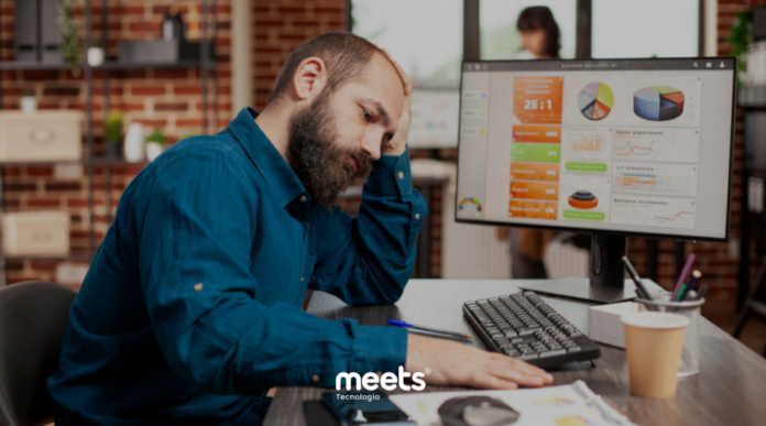 Gestor analisando relatórios de vendas no CRM no computador com dificuldade para interpretar dados e métricas comerciais.