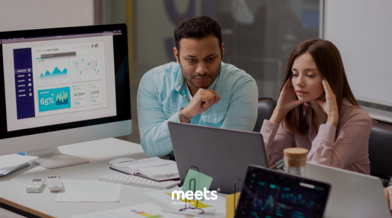 Profissionais de marketing em uma agência analisando dados de vendas e conversão de novos clientes na tela do computador.