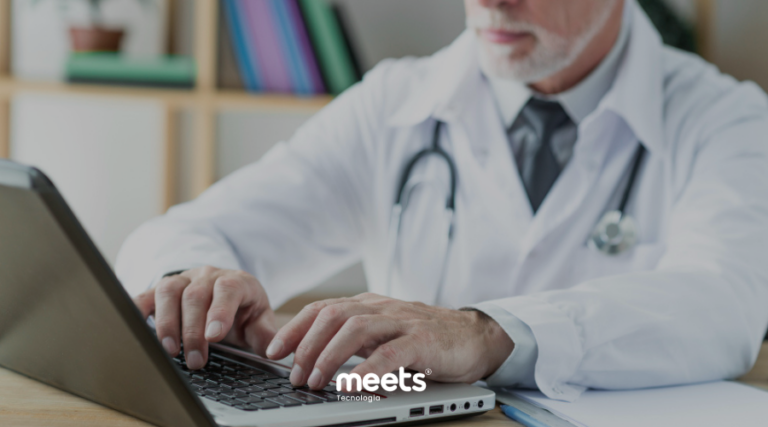Médico utilizando notebook em ambiente clínico para gestão de atendimentos e dados de pacientes com apoio de tecnologia e CRM na área da saúde.