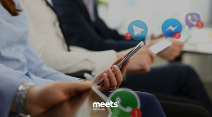 Pessoas utilizando smartphones enquanto recebem mensagens de diferentes aplicativos de comunicação, representando o atendimento em múltiplos canais.